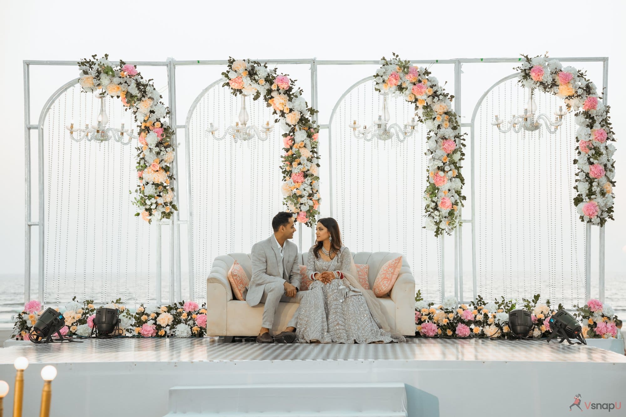 The groom and bride share an intimate moment, sitting on stage at their destination wedding.