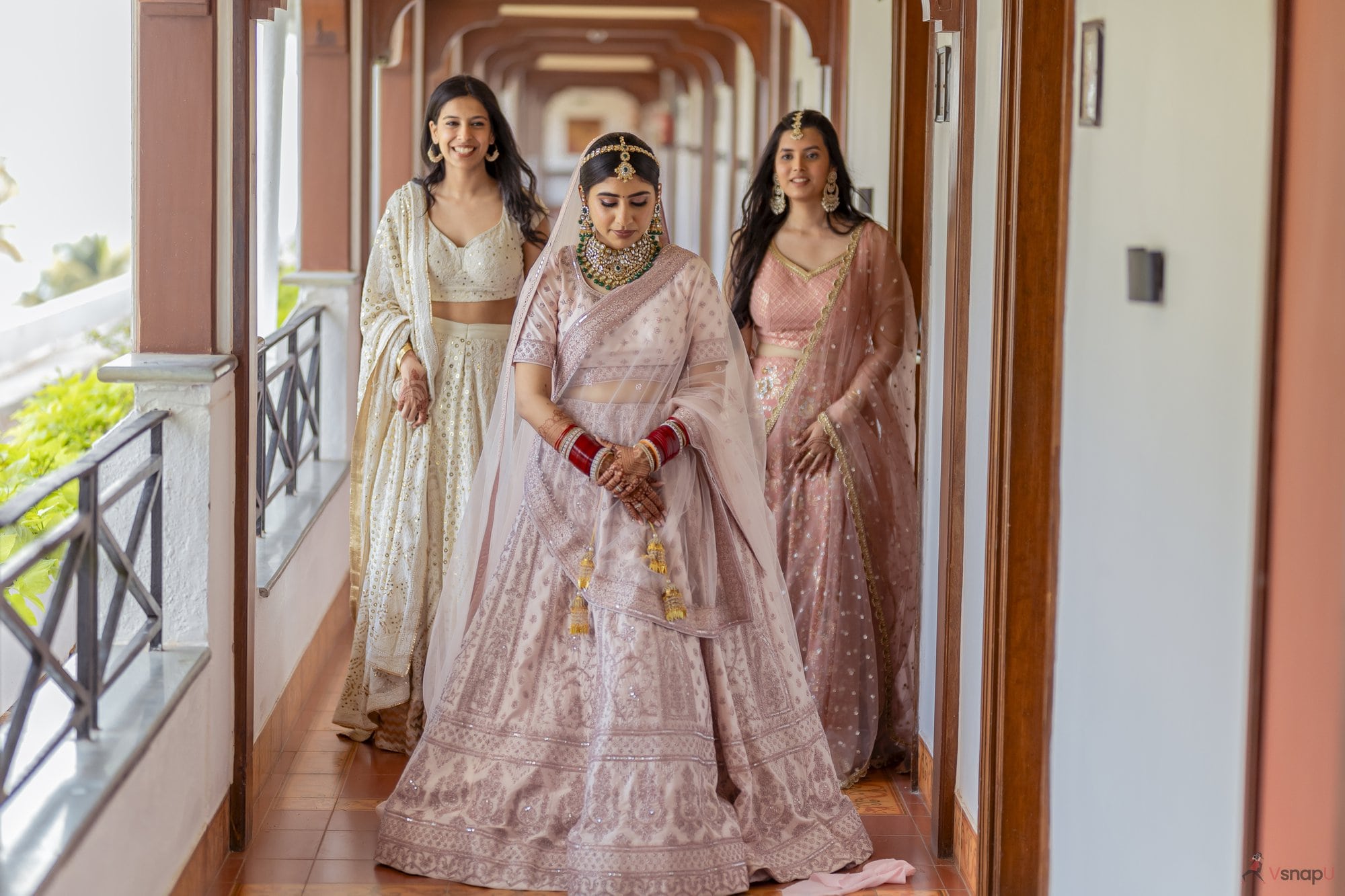 VsnapU captures the bride’s joyful walk with her sisters on a stunning balcony at their destination wedding in Jim Corbett.